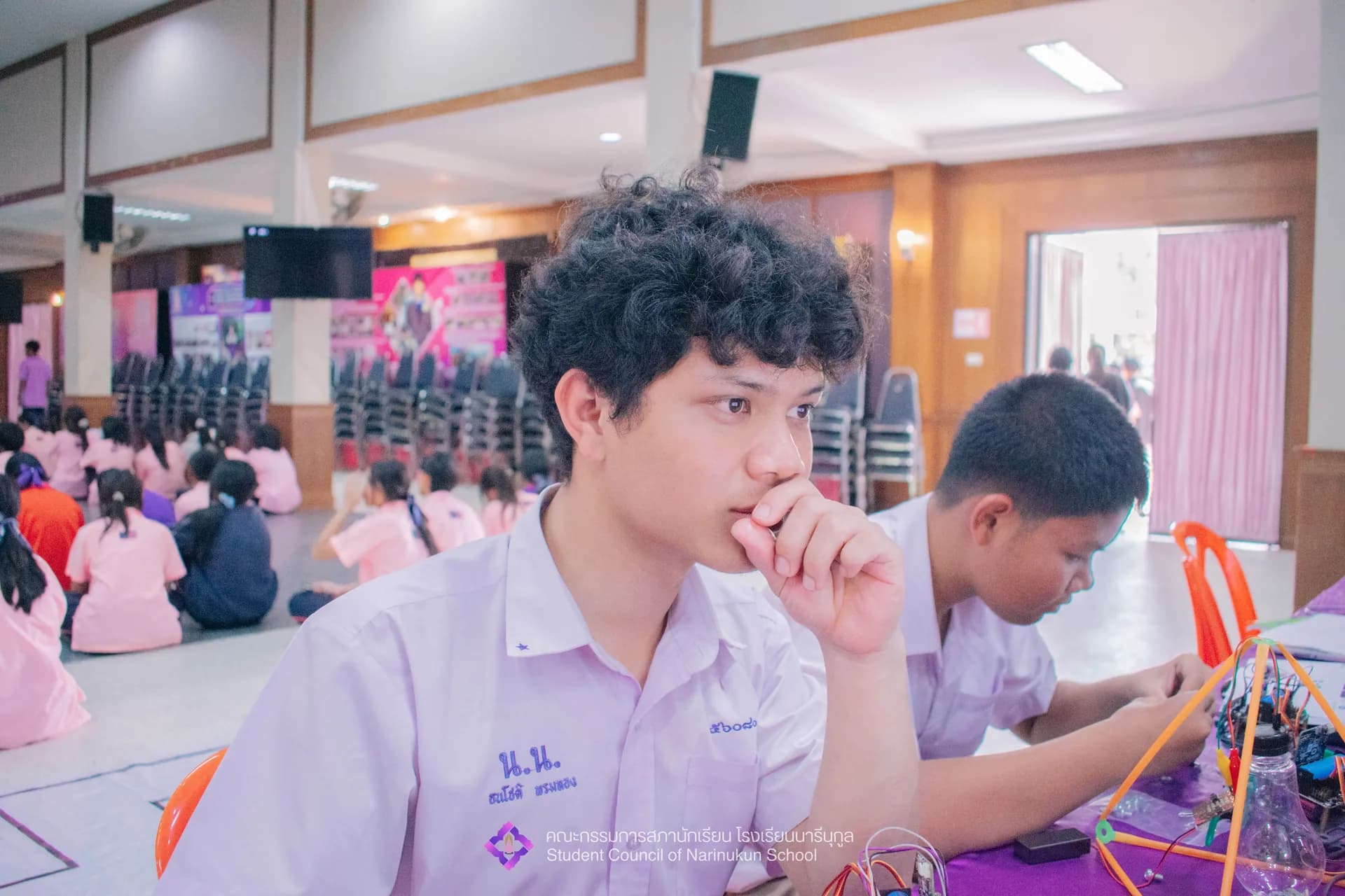 Thanachot Phomthong beside an electronics project at a school open house